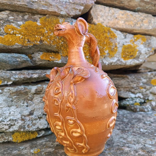 Handmade ceramic jug used with animal-shaped neck and embossed floral designs