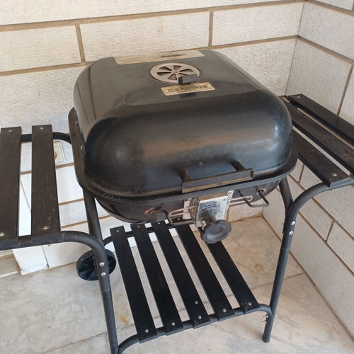 Charcoal grill used, wheeled with shelves and tools