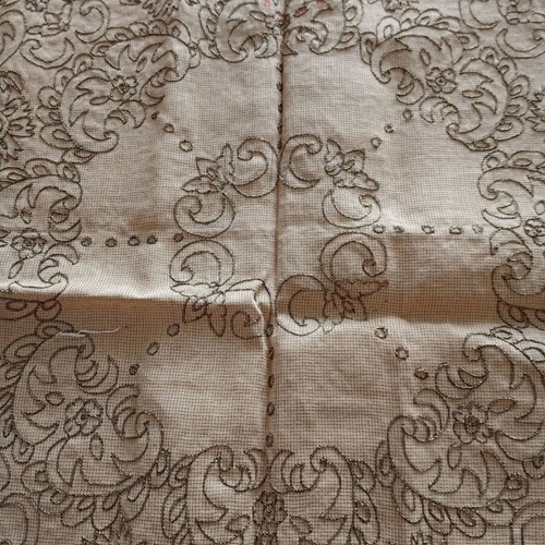 Stamped rosette with embroidered golden root on canvas
