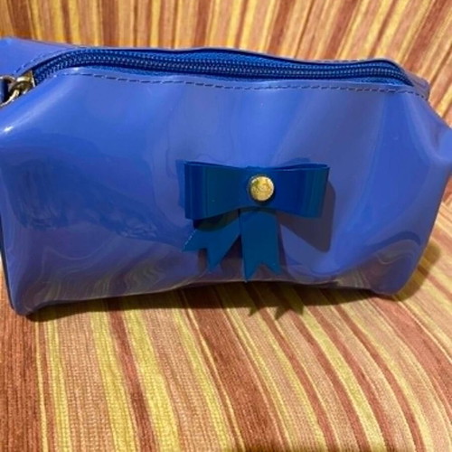 Shiny blue toiletry bag with decorative bow, like new
