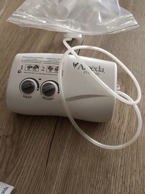 Ameda breast pump like new with two breast milk storage bottles