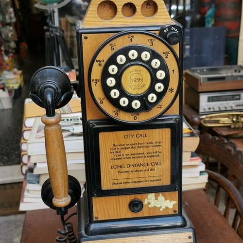 Vintage decorative wall telephone with clock used