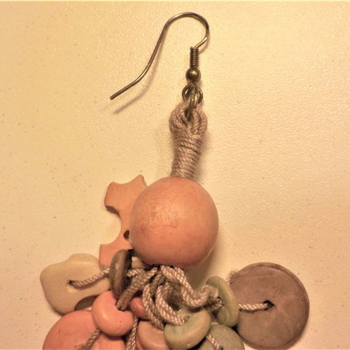 Long handmade earrings made of wood and cord in pastel colors