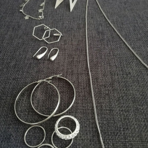 Various silver jewelry including earrings, body chain, rings, and necklace
