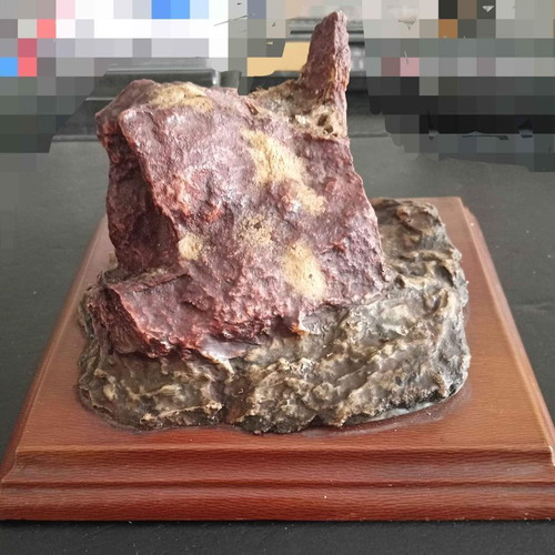 Decorative used piece with red mineral stone on wooden base