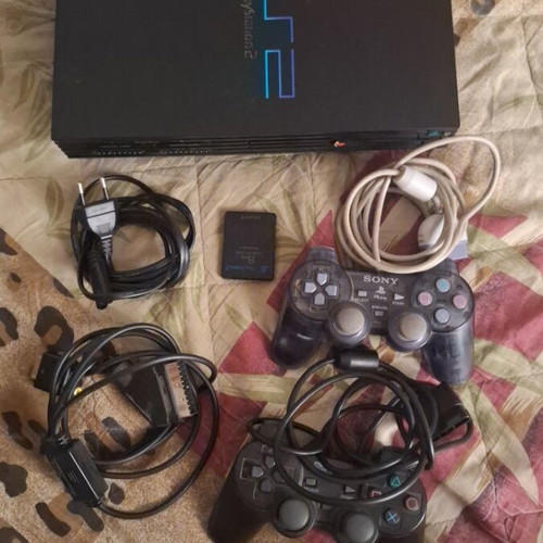 Sony PlayStation 2 console with 2 controllers, memory card and 5 games
