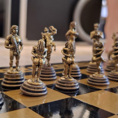 Chess set with decorative metal pieces and black-gold board