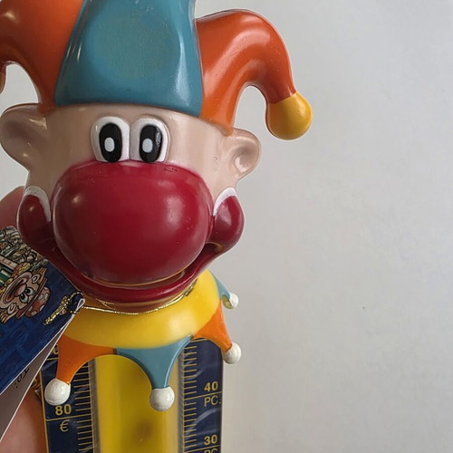 Vintage clown coin bank with yellow coin tube