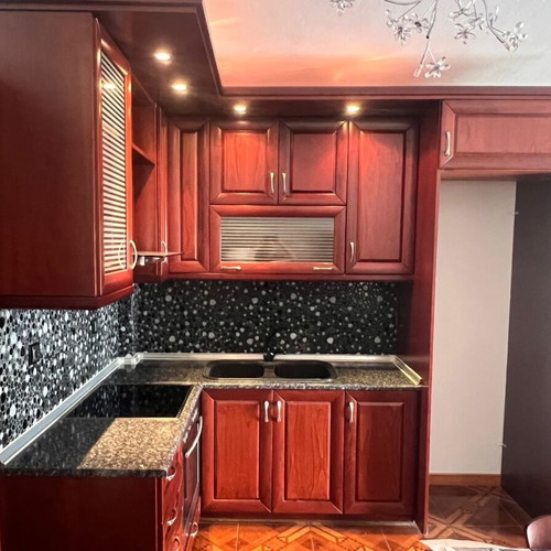 Corner kitchen made of solid cherry wood with extractor hood used