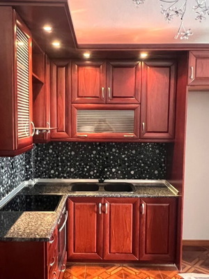 Corner kitchen made of solid cherry wood with extractor hood used