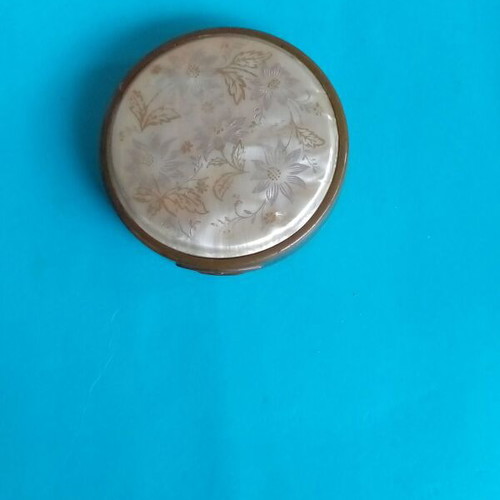 Antique powder compact used with metal bronze casing