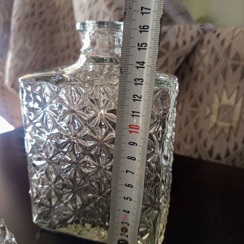 Vintage glass decanter with embossed geometric design and stopper