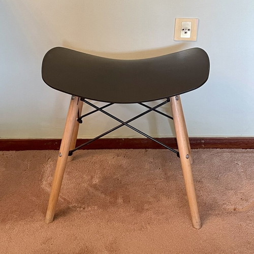 Low stool like new with black curved plastic seat and wooden legs