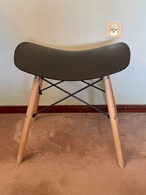Low stool like new with black curved plastic seat and wooden legs