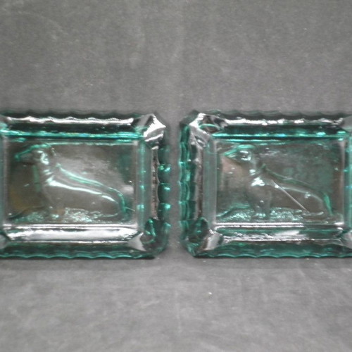 Antique ashtrays pair used with embossed dogs in dark green glass