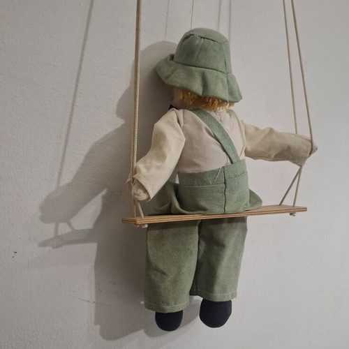 Porcelain clown doll on wooden swing, vintage collectible