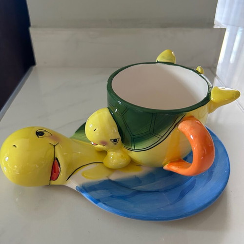 Vintage ceramic children's mug with turtle design used