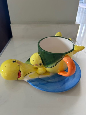 Vintage ceramic children's mug with turtle design used