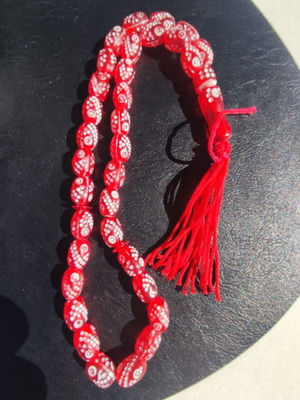 Lightweight red worry beads with carved white motifs like new