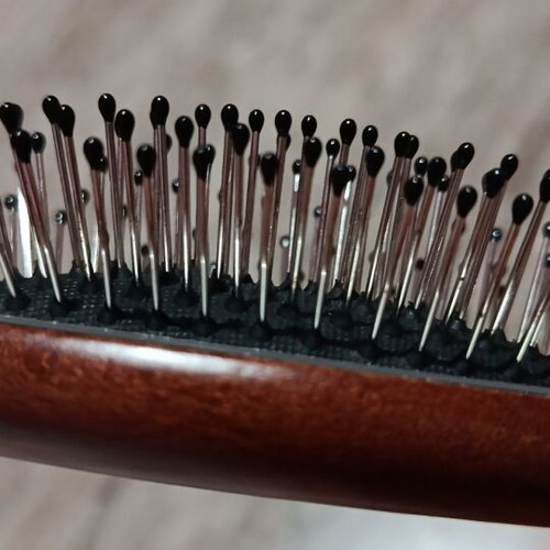 Small hairbrush with metal pins and rubber cushion