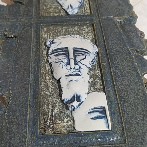 Handmade stone wall decoration with embossed ancient-style faces