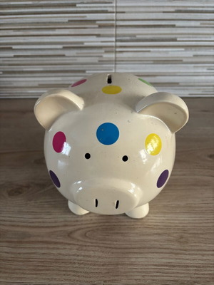 Ceramic pig-shaped piggy bank used with colorful polka dot design
