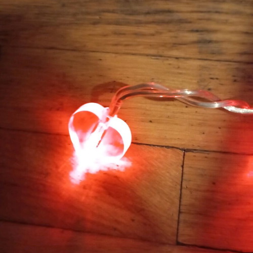 Heart-shaped string lights used with power, white cable
