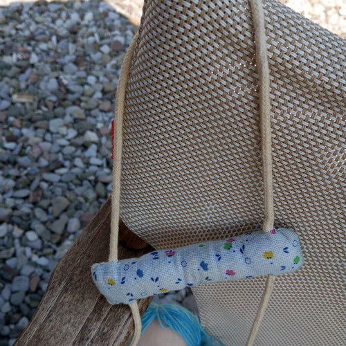 Cloth doll used, hanging in a swing