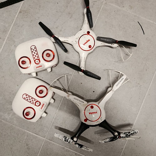 Syma drones used with controllers, two batteries and extra propellers