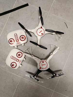 Syma drones used with controllers, two batteries and extra propellers
