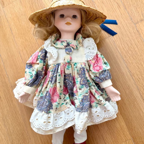 Porcelain doll like new with colorful dress and straw hat