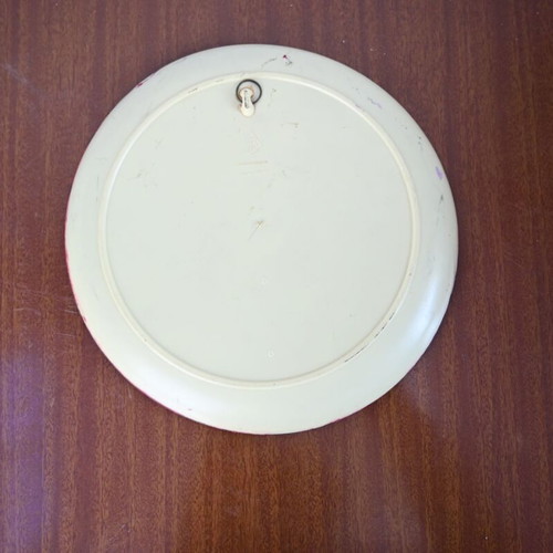 Decorative wall plate used with embossed female profile on burgundy background
