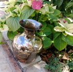 Intricately enameled brass vase with flowers.