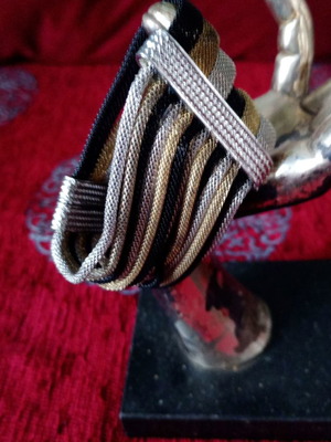 Magnetic bracelet used with silver, gold and black metallic details