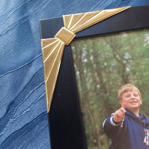 Black photo frame with golden decorative bows used