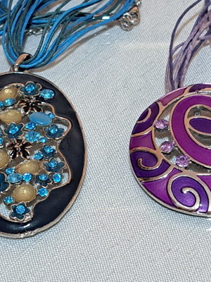 2 vintage metallic pendants with blue-green and pink-purple motifs
