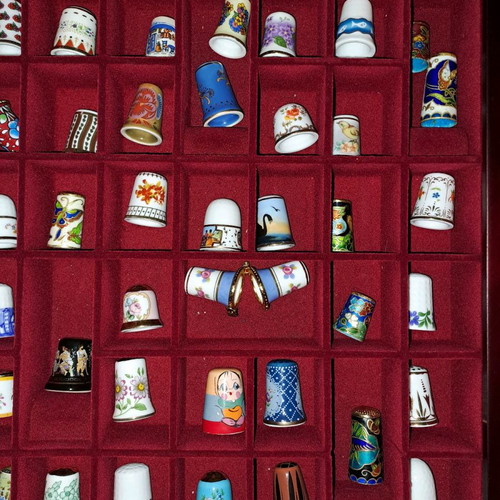 Porcelain thimble collection with wooden display case and book