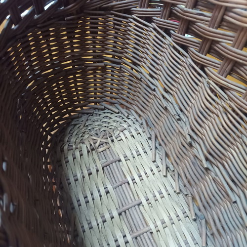 Handmade dark brown wicker basket with high arched handle