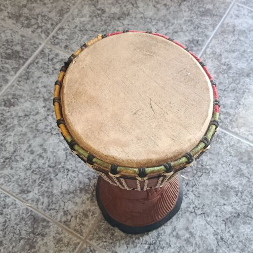 Wooden African drum with carved details and leather membrane