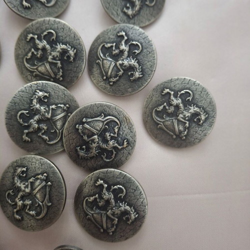 19 silver shield-style clothing buttons with lion design
