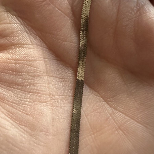 Gold plated bracelet snake chain herringbone style, worn with oxidation spots