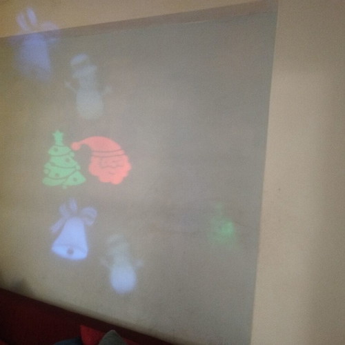 Projector lights with holiday designs used, snowman, Santa, fir tree