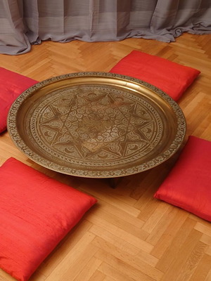 Moroccan brass tray table with silk floor cushions