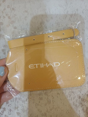 Yellow luggage tag with white stitching and strap, new