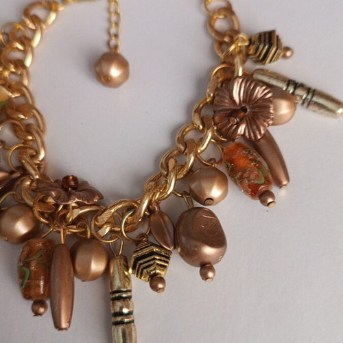 Gold bracelet with various charms handmade from scratch