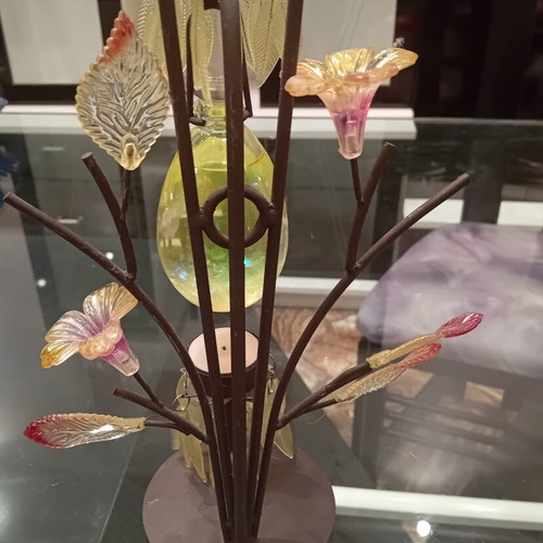 Decorative candle holder with metal tree base, used