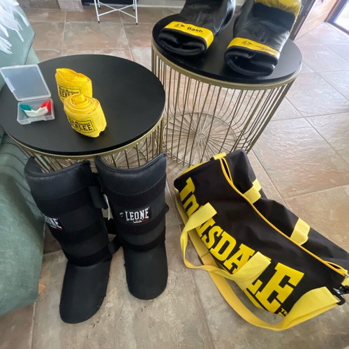 Kick boxing equipment used with gloves, wraps, shin guards, mouthguard, and bag