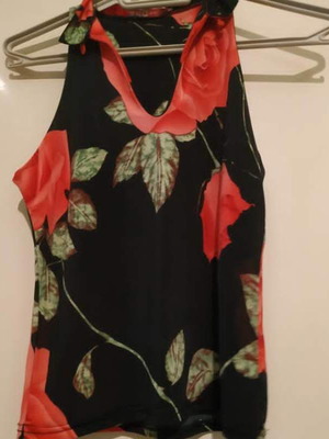 Sleeveless blouse used with black background and floral design