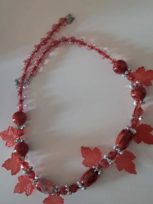 Handmade red necklace with beads and decorative leaves like new