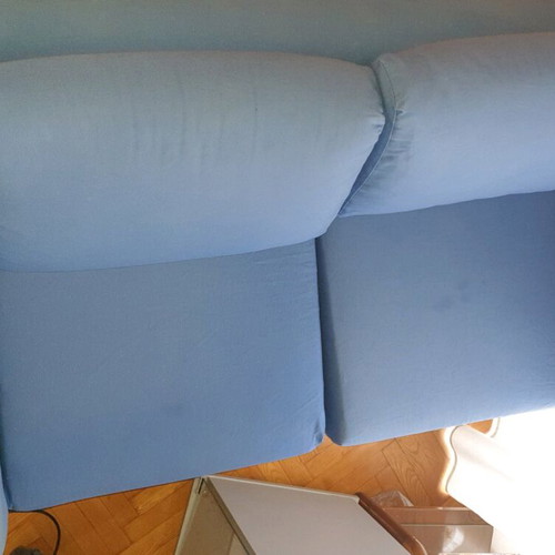 Two-seater sofa used without two back cushions